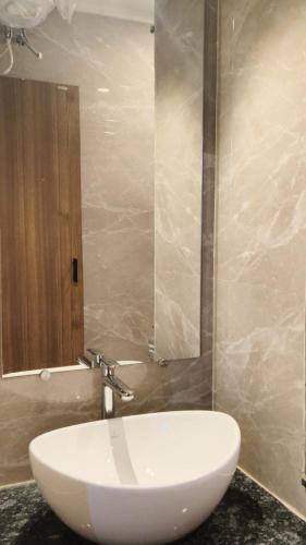 a bathroom with a white sink and a mirror at Hotel The Amrit in Jabalpur