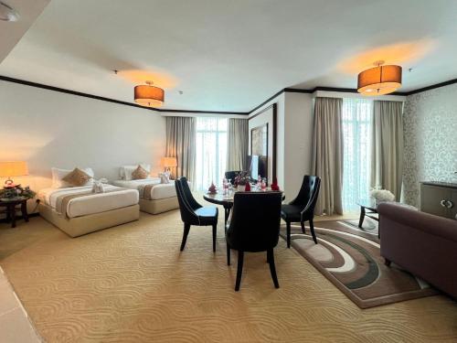 a living room with a bed and a table and chairs at Adya Hotel Kuah Langkawi in Kuah