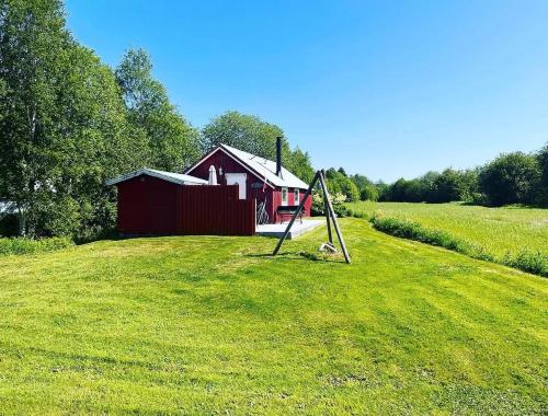 a swing set in a field with a red barn at Bakerstu in Skage i Namdalen