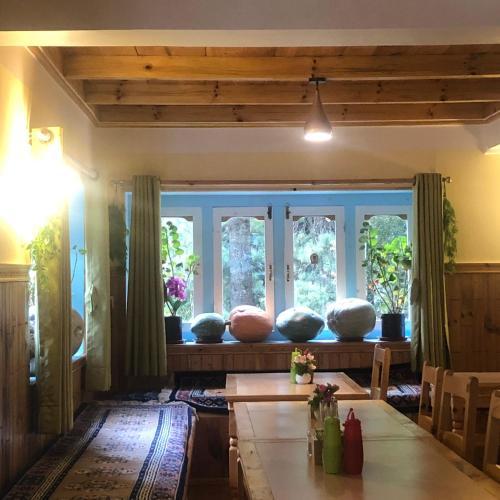 a living room with a table and some windows at Hotel Waterfall Benkar in Phakding