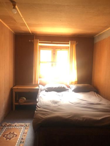 a bed in a room with a window at Hotel Waterfall Benkar in Phakding