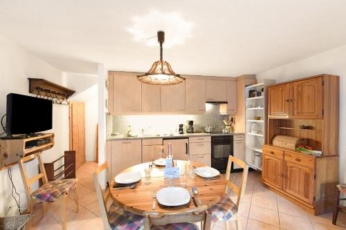 a kitchen with a wooden table and a dining room at Rustico Alla Bolla - Val Verzasca - Happy Rentals in Frasco