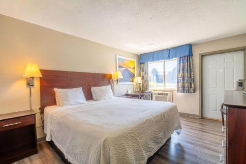 a hotel room with a large bed and a window at Days Inn by Wyndham Sioux City in Sioux City