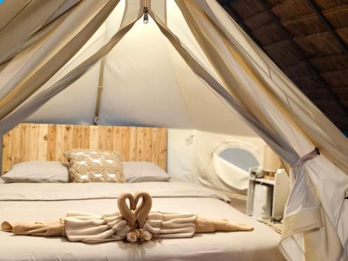a bedroom with a bed with two hearts on it at Nai Suan Phan Resort - ในสวนฝัน รีสอร์ท in Ban Thung Samoe
