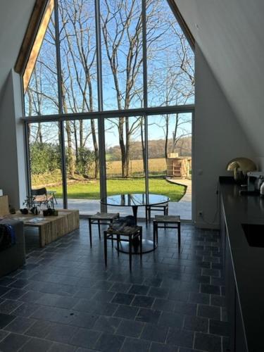 a room with a table and benches and a large window at Nordic Bath Lodge In Normandy in Donnay