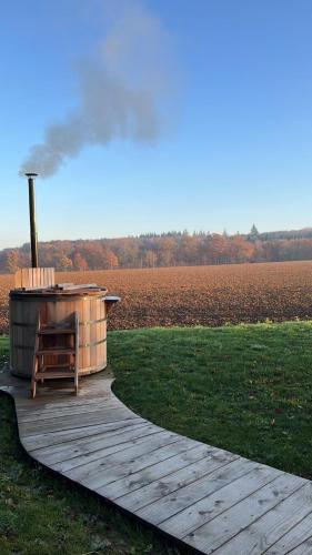 a wooden deck with a hot tub in a field at Nordic Bath Lodge In Normandy in Donnay