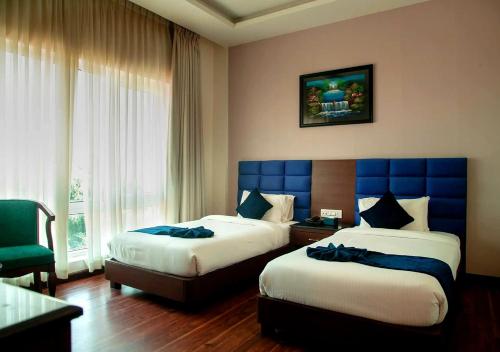 a hotel room with two beds and a window at Nepalirika Hotel Biratchowk in Haraincha