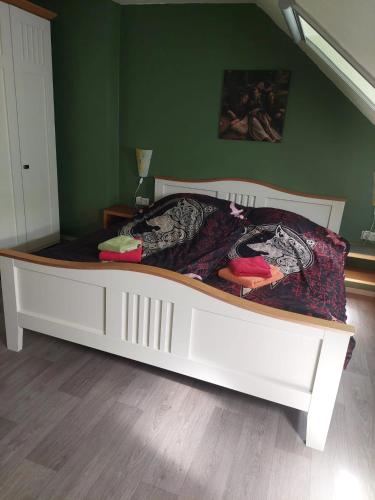a white bed in a room with a green wall at Viking in Heede