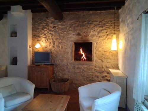 a living room with a fire in a stone wall at Casa Rural Hosteria Cantarranas in Cuacos de Yuste