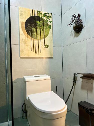 a bathroom with a toilet and a painting on the wall at Farm Village in San Juan