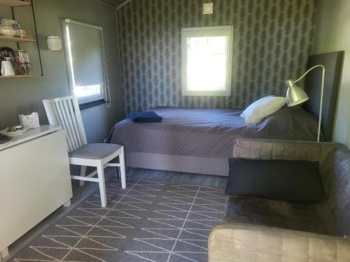 a bedroom with a bed and a chair and a couch at Norrtälje in Norrtälje