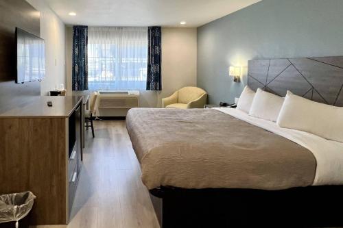 a hotel room with a large bed and a desk at Quality Inn Tracy I-205 in Tracy