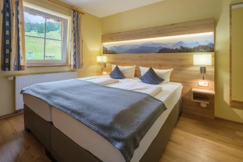 a bedroom with a large bed with a large window at Gasthof Schwabenhof in Balderschwang