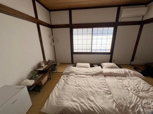 a bedroom with two beds and two windows at 아라무사aramoosa민숙 in Tsushima