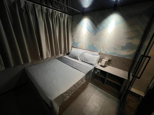 a small bedroom with a bed and a painting on the wall at Where Inn in Hong Kong