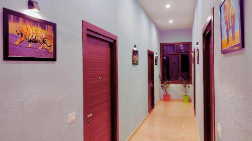 a hallway with purple doors and a painting of a tiger at Asapian Vanyamahal - A Nature Resort in Rāmnagar