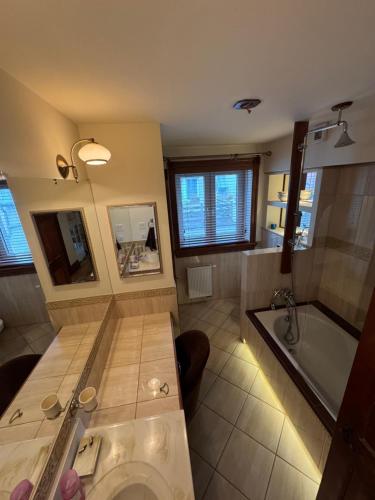 a large bathroom with a tub and a sink at Apartament Centrum in Augustów