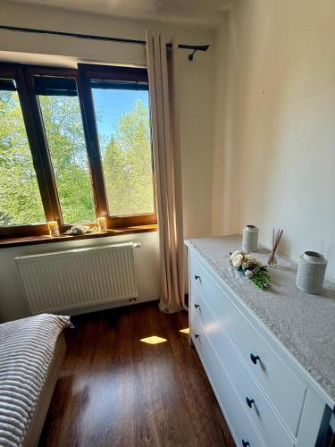 a bedroom with a bed and a dresser and windows at Apartmán Lara -Lesná in Stará Lesná