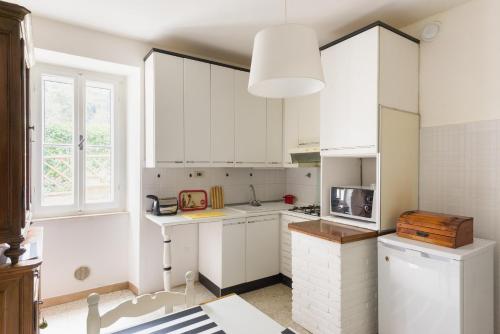 a kitchen with white cabinets and a window at Un Petit Paradis in Castiglione della Valle