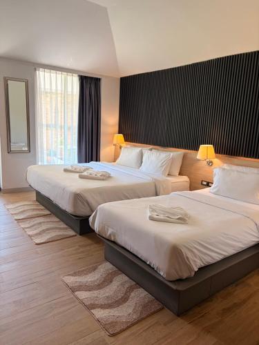a hotel room with two beds with lamps on them at i-river chiangmai in Chiang Mai