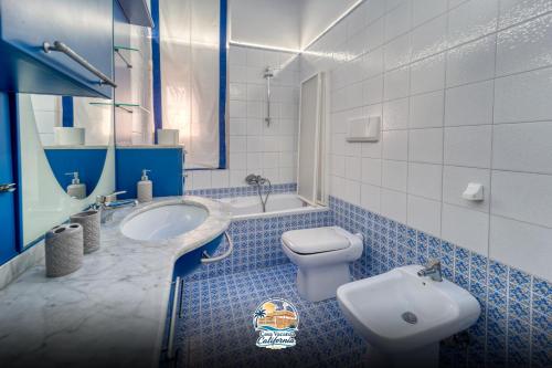 a blue and white bathroom with a toilet and a sink at Casa Vacanza California in Bari