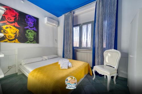 a bedroom with a bed with a yellow blanket and a chair at Casa Vacanza California in Bari