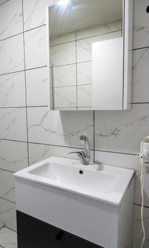a white bathroom with a sink and a mirror at RİO's HOTEL KURTKÖY in Istanbul