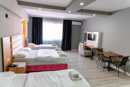 a hotel room with two beds and a desk at RİO's HOTEL KURTKÖY in Istanbul