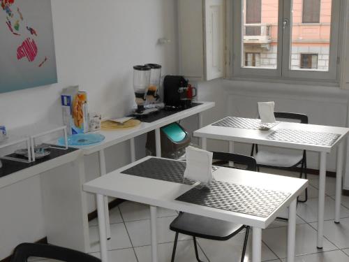 a kitchen with two white tables with laptops on them at Aldebaran in Milan
