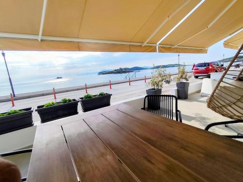 a table on a balcony with a view of the ocean at Aurora suite in Nea Peramos