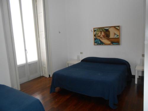 a bedroom with two beds and a picture on the wall at Aldebaran in Milan