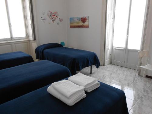 a room with three beds with blue sheets at Aldebaran in Milan