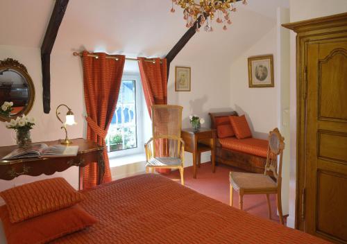 a bedroom with a bed and a desk and a window at Hostellerie de la Motte jean in Saint-Coulomb