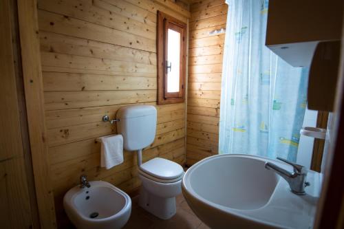 Un baño de madera con inodoro y lavabo. en Villaggio Marbella Club, en Palinuro