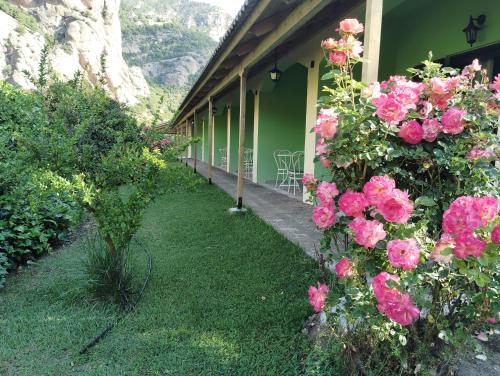 a house with pink roses on the side of it at Guesthouse Eleftherios in Kalavrita