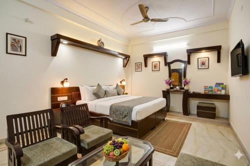 a hotel room with a bed and a chair and a table at Hotel Royal Prithvi Palace Near Ghaziabad Railway Station in Ghaziabad