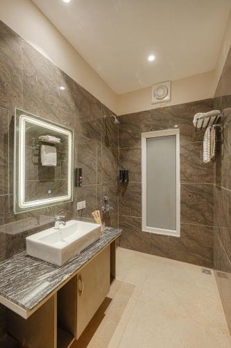 a bathroom with a sink and a mirror at Reejas inn's n' suites in Kasauli