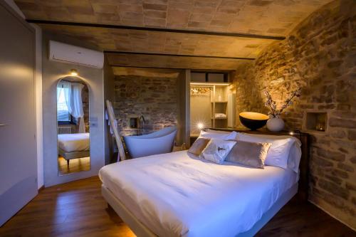 a bedroom with a bed and a stone wall at Charme in Spello in Spello
