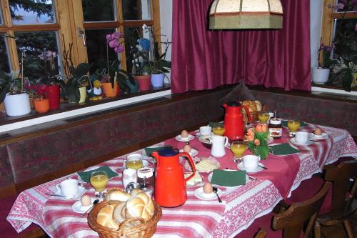 a table with red vases and food on it at Haus Morgensonne in Pettneu am Arlberg