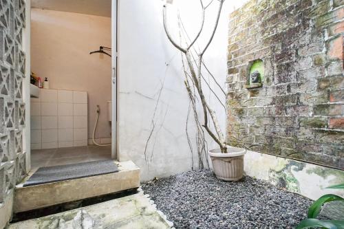 a bathroom with a plant in a pot next to a brick wall at Citra Condong Catur in Seturan