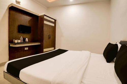 a bedroom with a white bed and a television at Hotel O Taj Nagri Near Taj Mahal East Gate Formerly Riviera in Agra