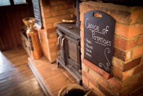 a brick wall with a sign on a fireplace at The Burley Inn in Burley