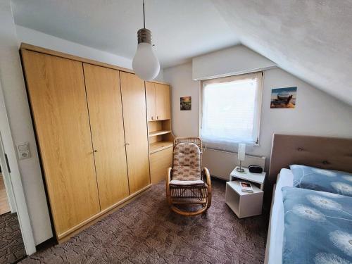 a bedroom with a bed and a chair in it at Willkommen bei Renate und Jörg in Unna