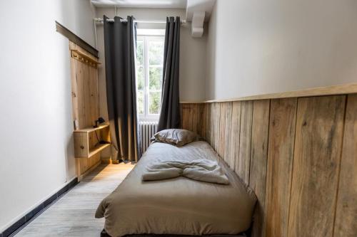 a bed in a room with a window at Au p'tit tchestê in Hontanx