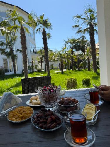 a table with food and drinks on a table with palm trees at Gabala Palm Villa in Gabala