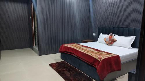 a bedroom with a bed with a red blanket at Hotel Skyline in Kanatal