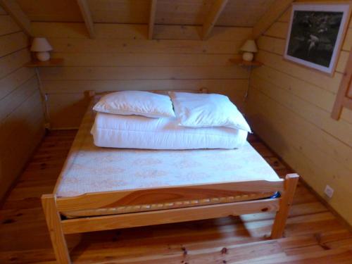 a bed in a cabin with two pillows on it at chalets de combebelle in Saint-Léger-les-Mélèzes