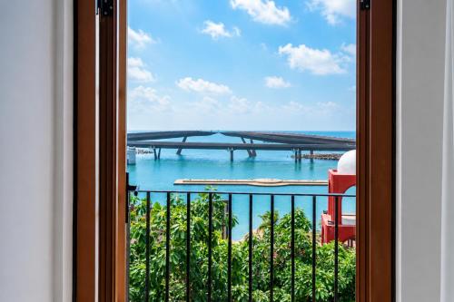 a window with a view of the water and a bridge at Noska Hotel Sunset Town Sea View & Fireworks in Phú Quốc