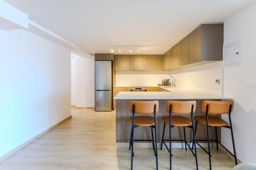 a kitchen with a counter and four stools at Old Town 63 in Paphos