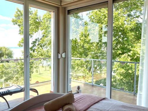 a bedroom with a bed and a large window at Gruber Apartman in Siófok